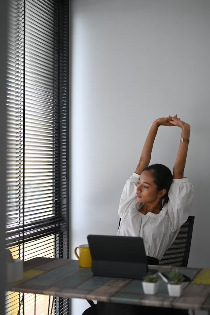  Desktop employee stretching safely with proper posture support
