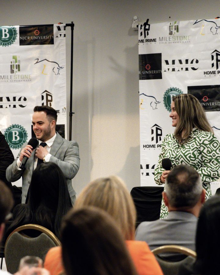 Ludwin Alvarez hablando en un panel frente al backdrop con el logo de MMC