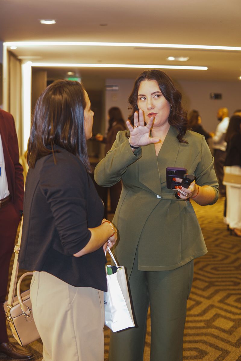 Yanelia conversando con una asistente en un evento