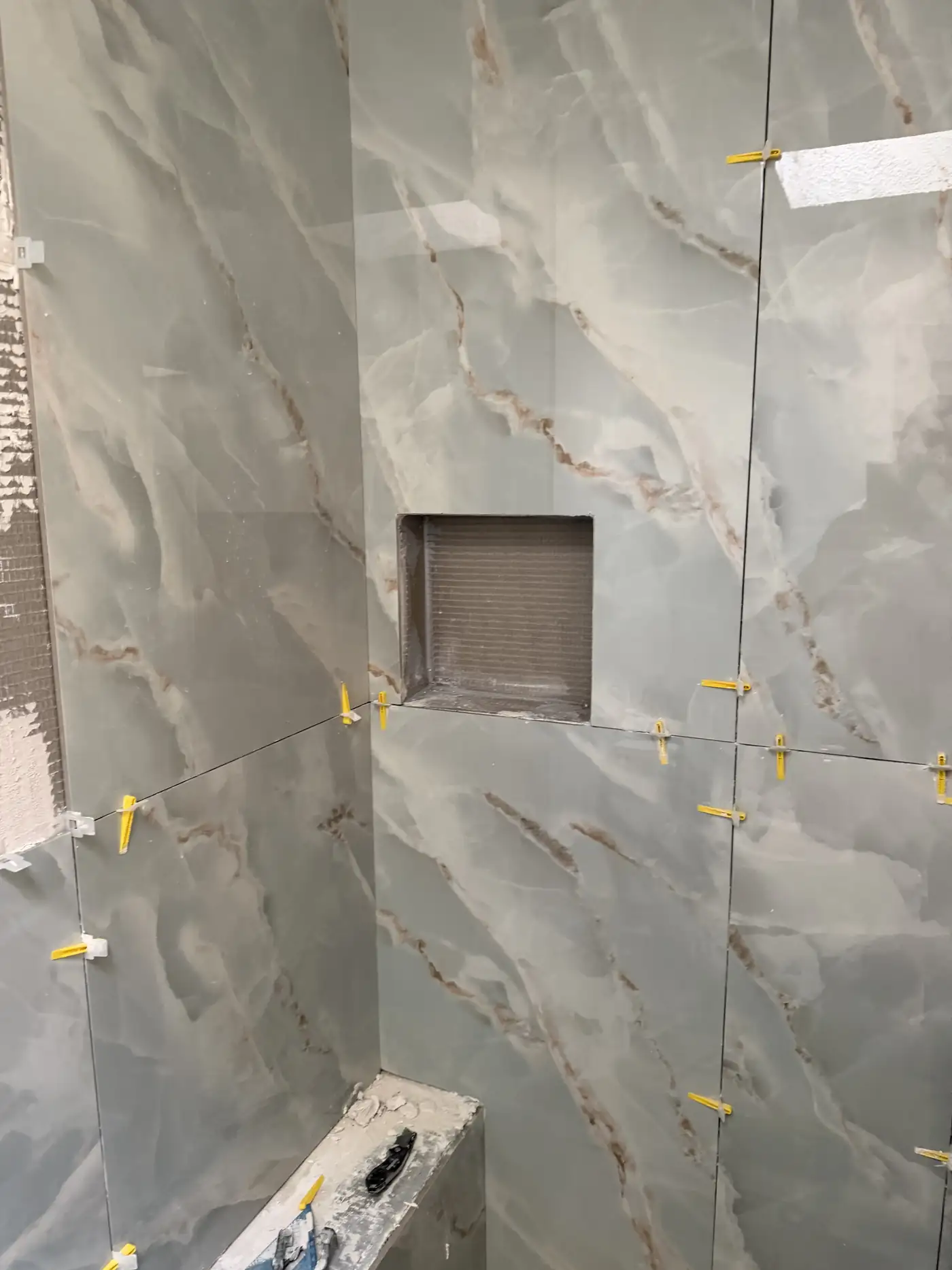 Finished marble tile shower with a built-in niche from a Savannah bathroom renovation