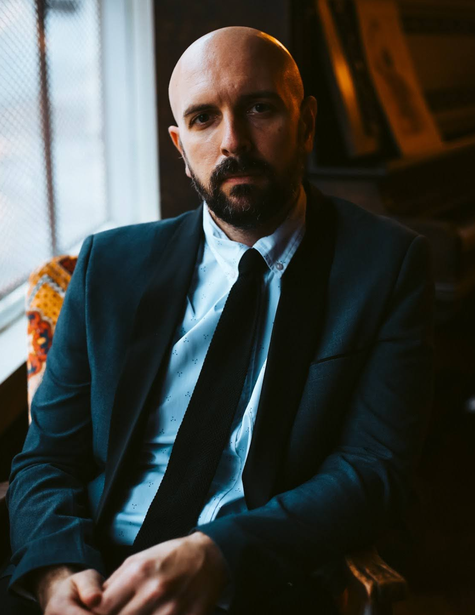 Dr. Anthony Neely seated by a window