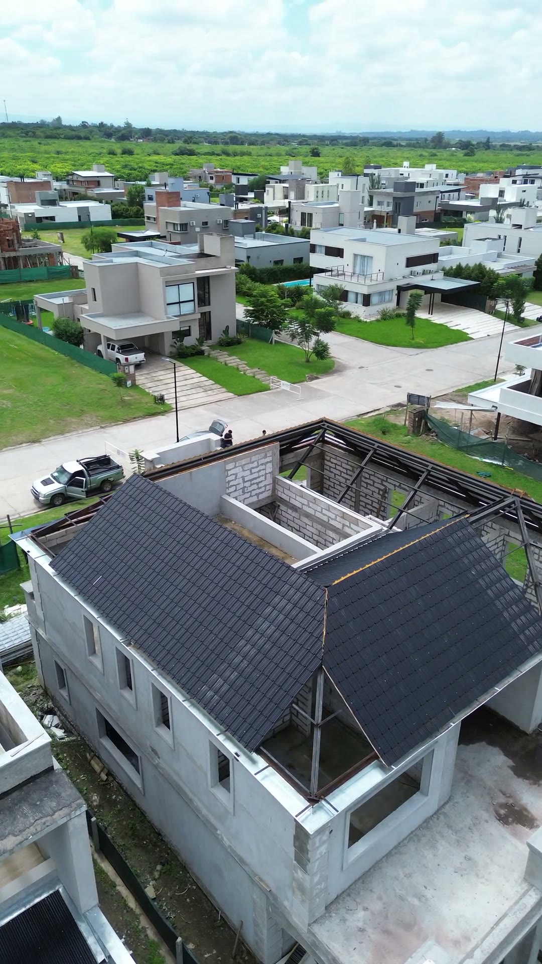 Casa de dos plantas con techo de tejas en barrio premium verde, en obra