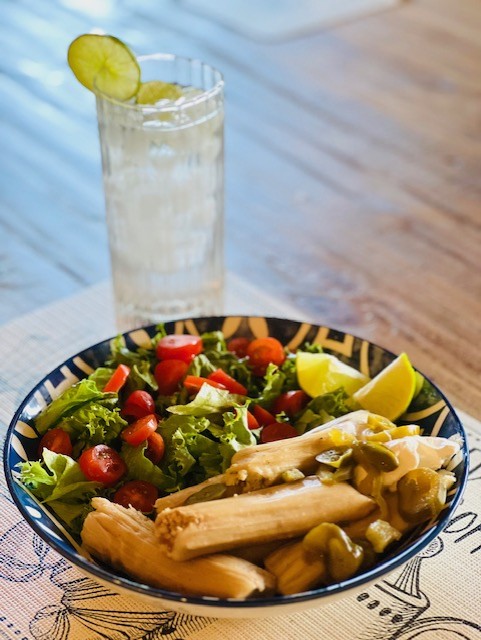 A bowl of tamales and a side salad.