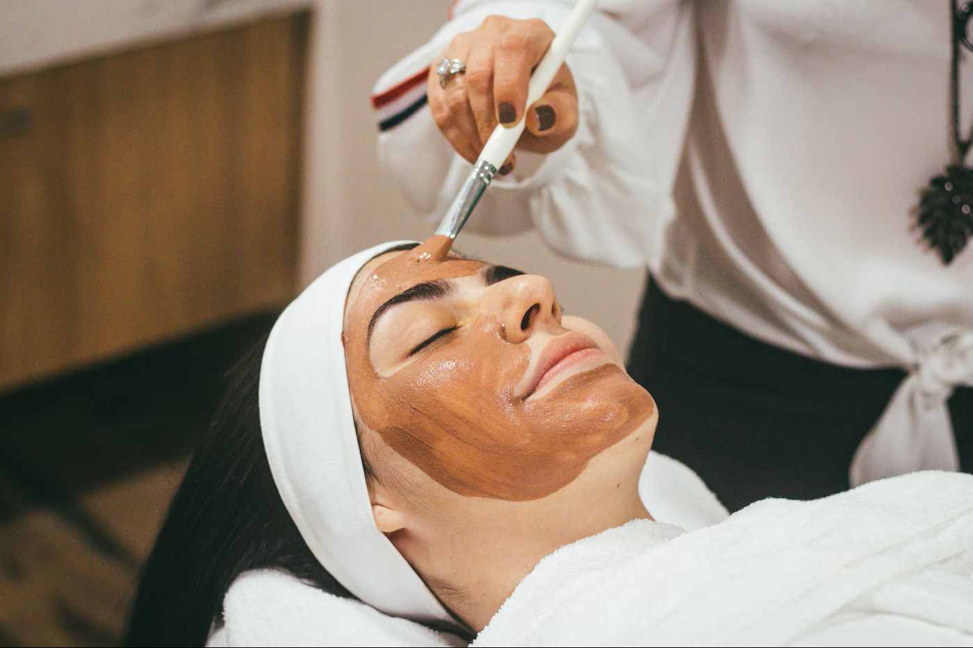 A peaceful facial treatment with a skincare mask gently applied by hand