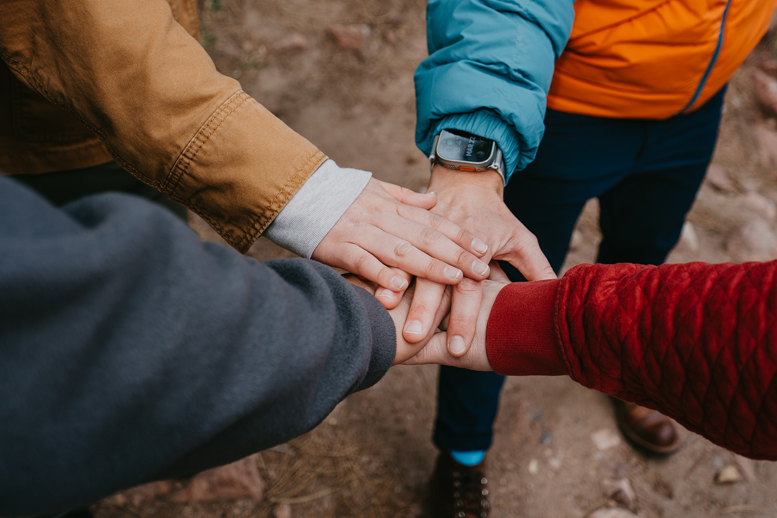 A team stacking hands together outdoors