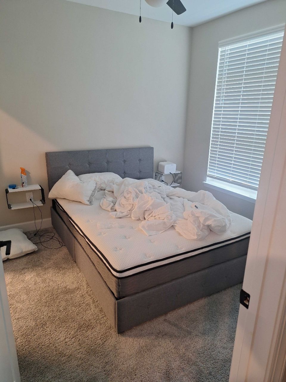Before: unmade bed, bedding piled, in an Atlanta bedroom