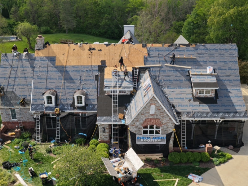 Roofing crew installing new roof replacement
