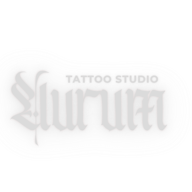 Wide-angle, high-end tattoo studio interior with leather seating, brass fixtures and warm ambient lighting; shallow depth, cinematic mood, photographic style emphasizing luxury and calm; composition centers the tattoo workstation and plush seating area.