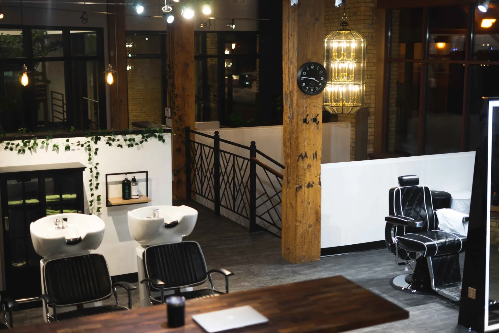 Studio AZ Barbershop interior — wash basins, barber chair, exposed timber column, and brass pendant lighting at the North Loop Minneapolis location