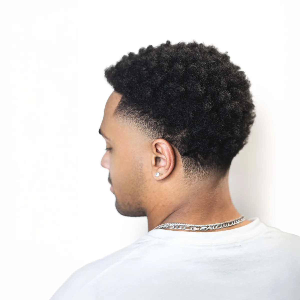 Black men's haircut with taper fade and clean line-up on coily hair — Afro fade at Studio AZ Barbershop, North Loop Minneapolis