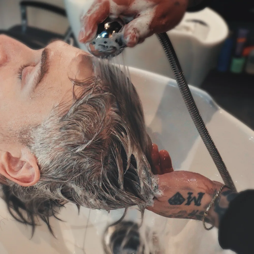 Client getting a warm scalp rinse at Studio AZ Barbershop in the North Loop, Minneapolis