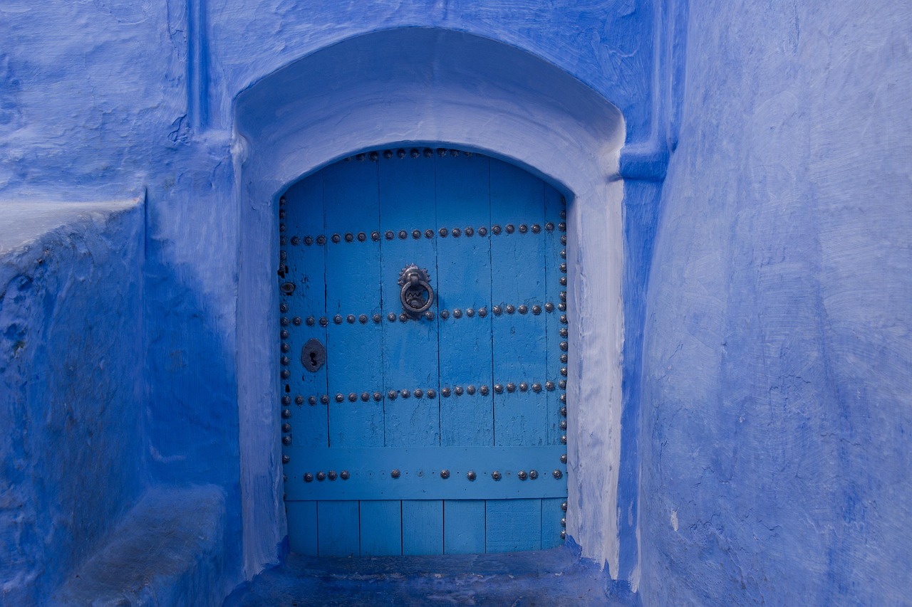 A blue wooden front door with an ornate brass door knocker