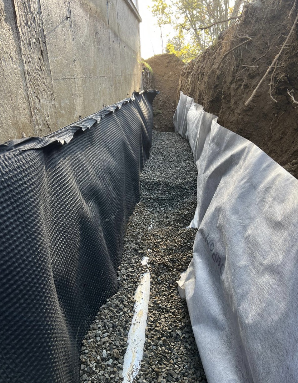 Basement waterproofing system installed along the perimeter of a residential basement