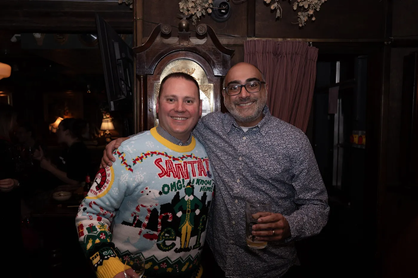 Two members in Christmas jumpers smiling together