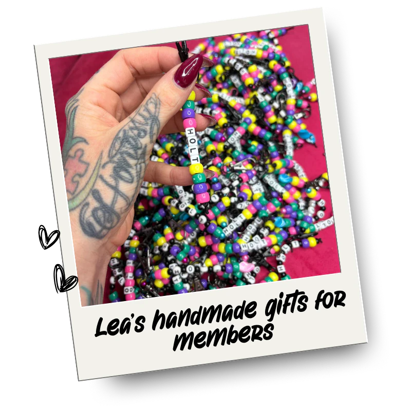 A person with tattoos on their hand holding a beaded keyring spelling 'HoLT' and the photo tag says "Handmade gifts from Lea"