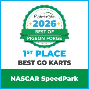 Racers speeding around the go-kart track at NASCAR SpeedPark