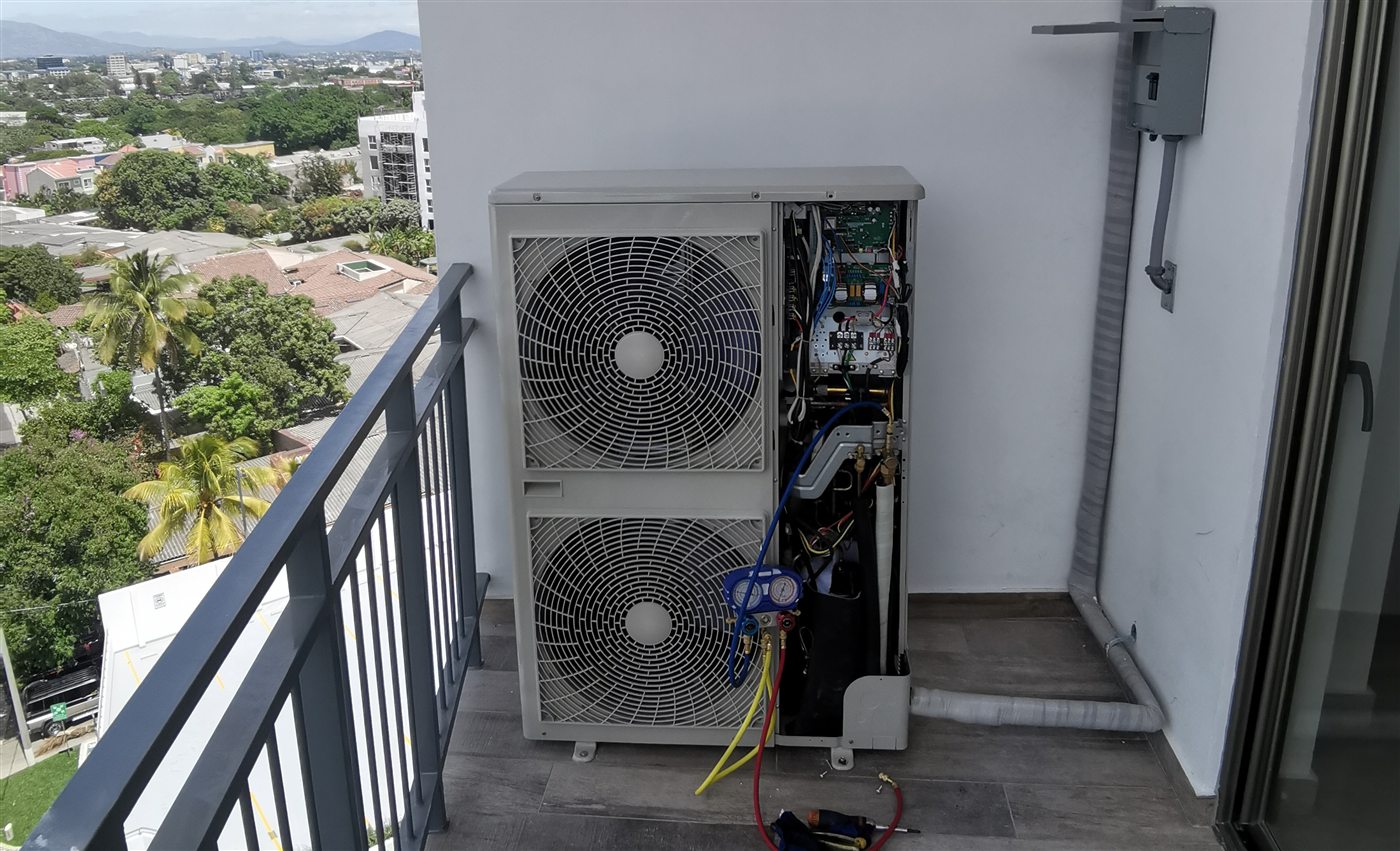 Equipo de aire acondicionado instalado por Aire Plus en el balcón de un apartamento en San Salvador