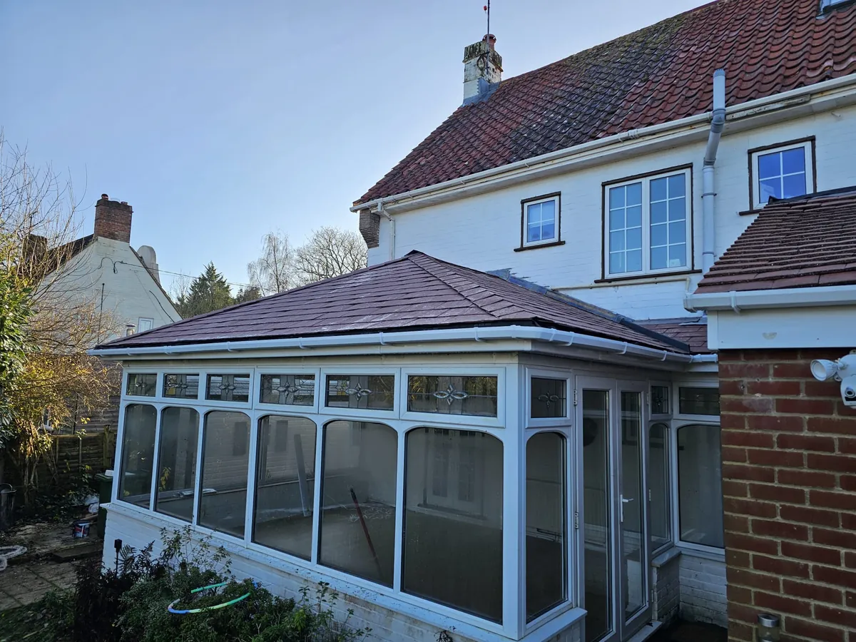 Conservatory with a new tiled roof and white guttering