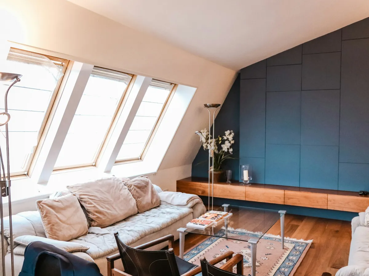 Loft living room with three roof windows in the sloping ceiling