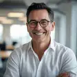 Headshot of a cheerful middle-aged man smiling outdoors at a cafe for Tyler S. testimonial