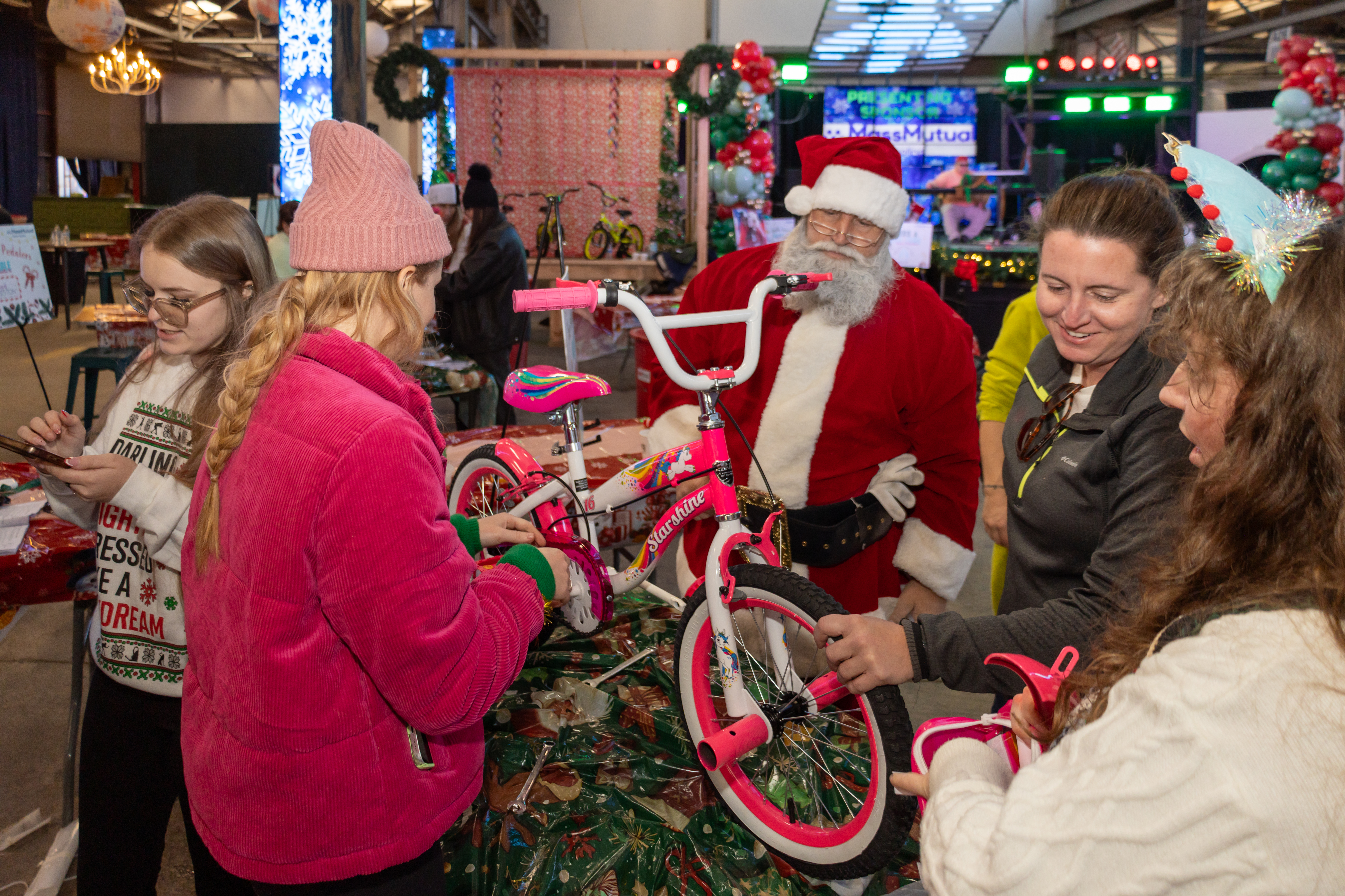 Volunteers wheeling completed bikes to the reveal