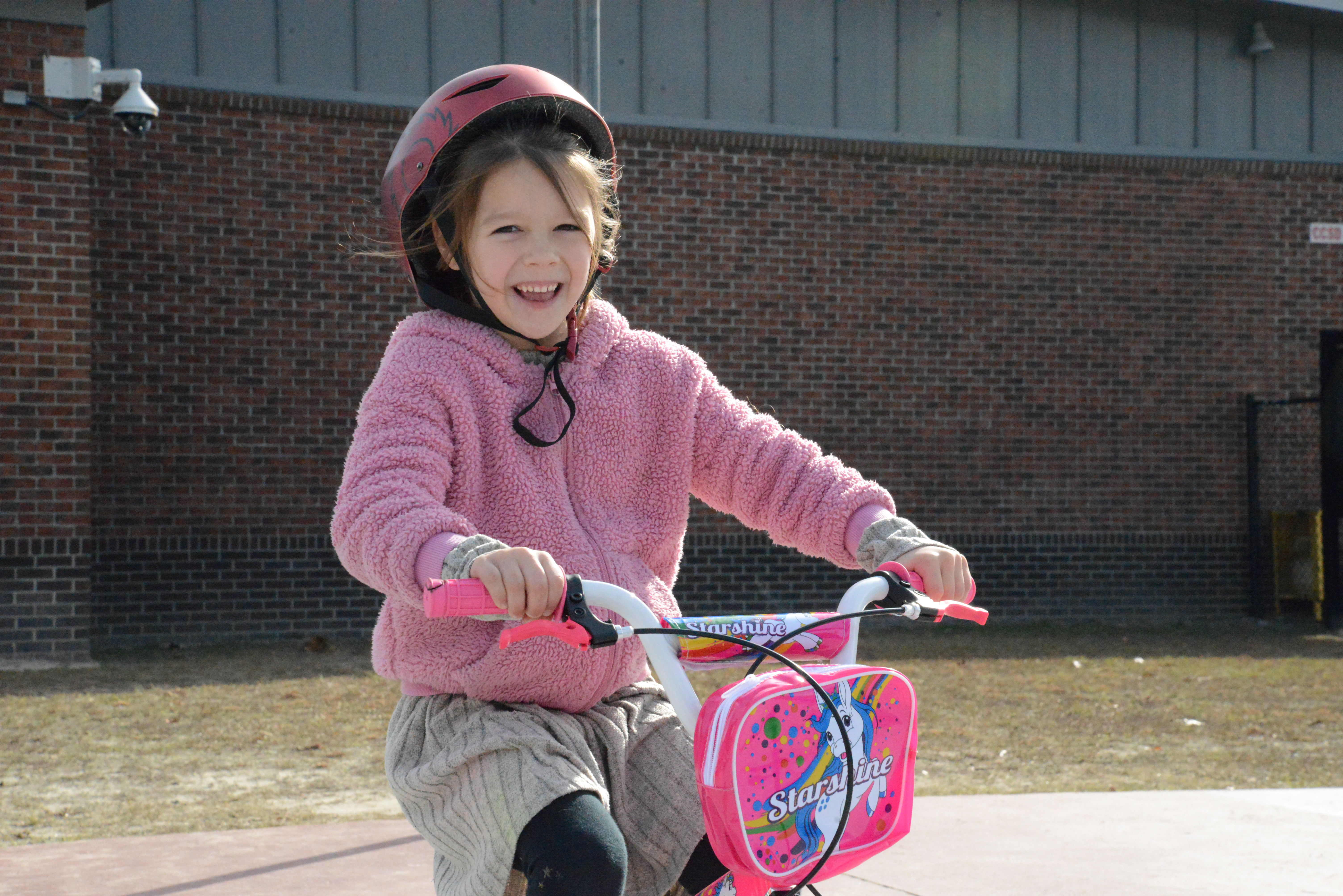 A child sitting on their brand-new bike at a Going Places reveal