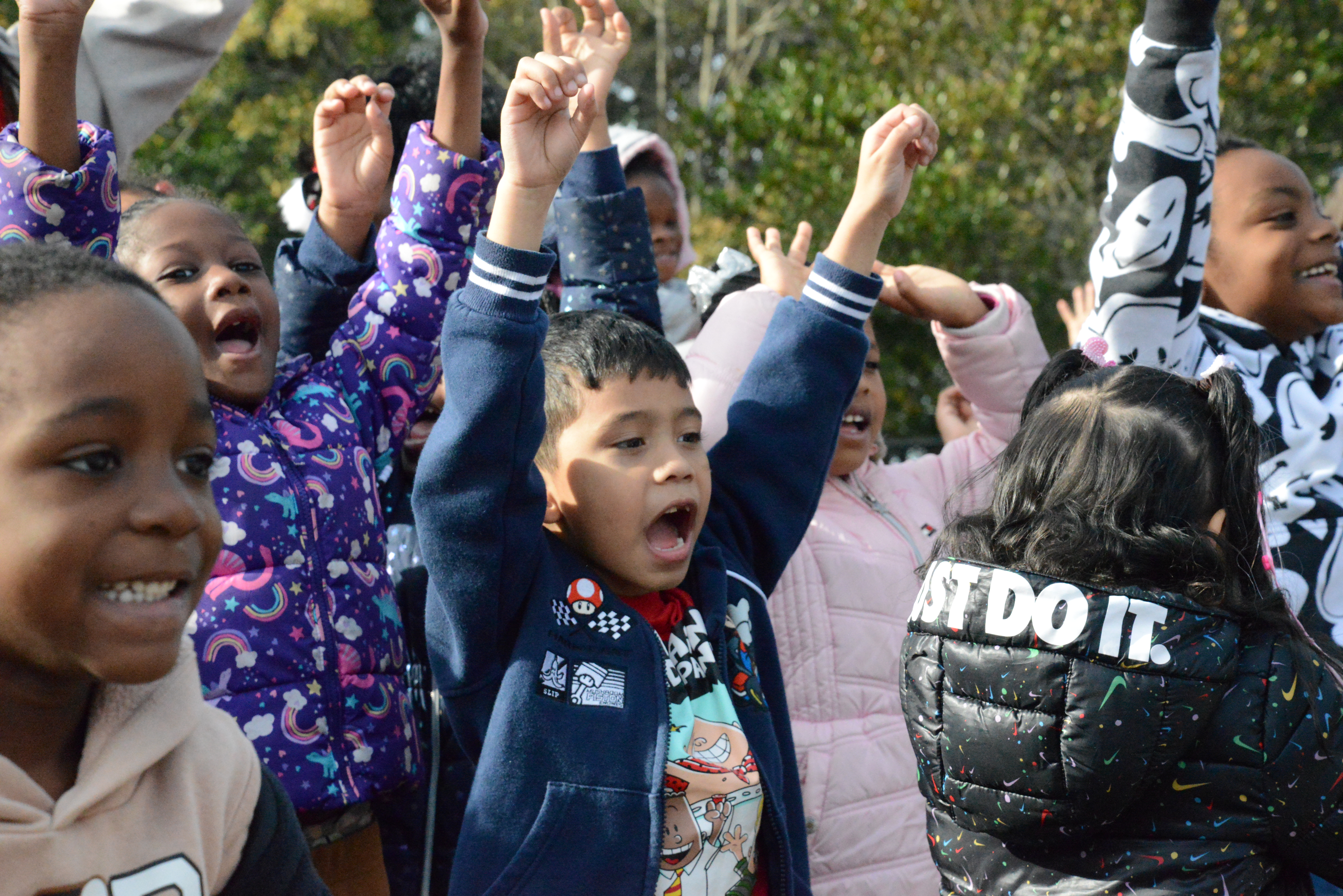 Children cheering as the cover comes off a room full of bikes at a school reveal
