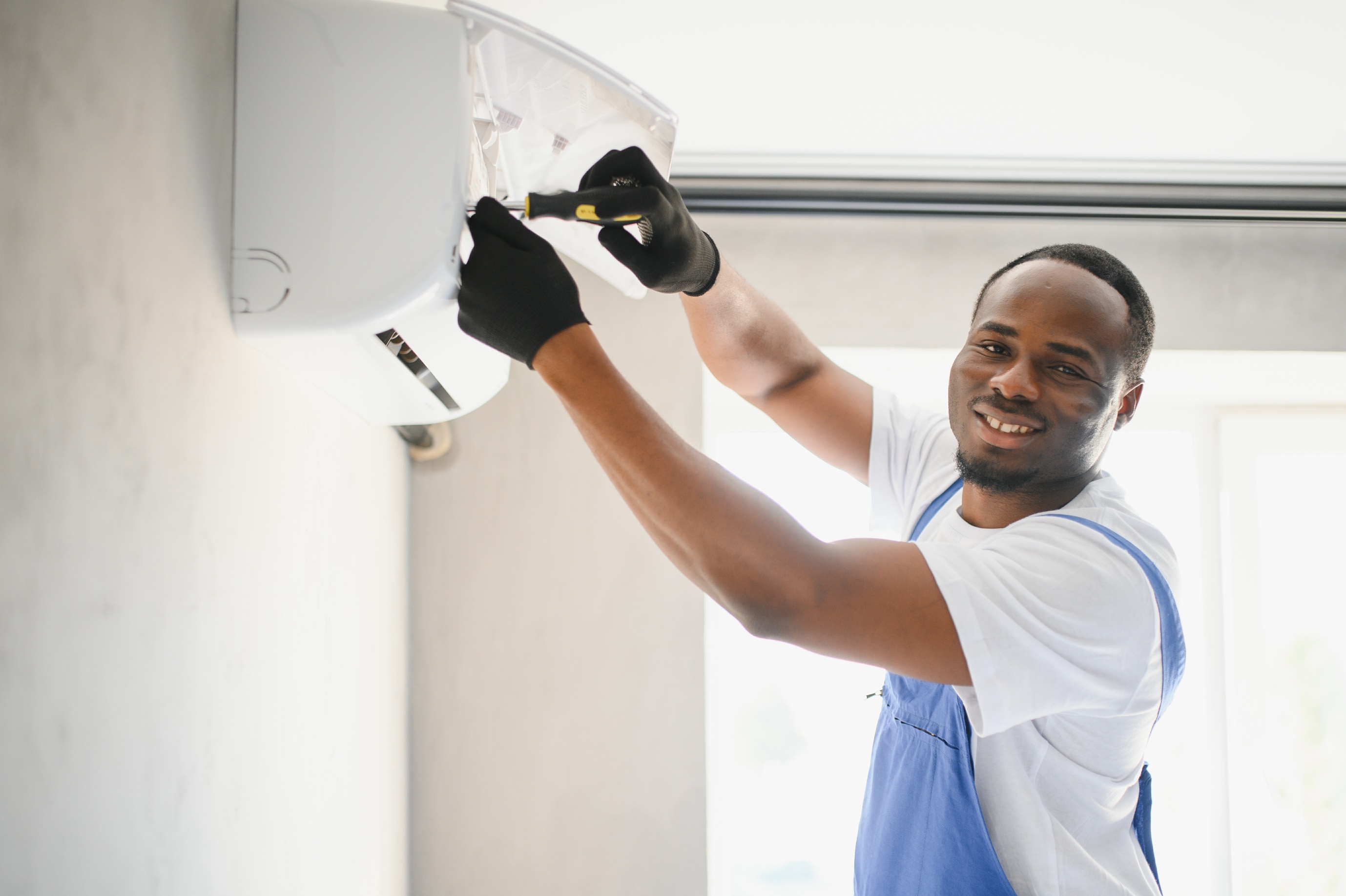 Technician repairing an air conditioning unit, highlighting the importance of labor, parts, and system complexity in determining the cost of AC repairs. Technician repairing an air conditioning unit, highlighting the importance of labor, parts, and system complexity in determining the cost of AC repairs.