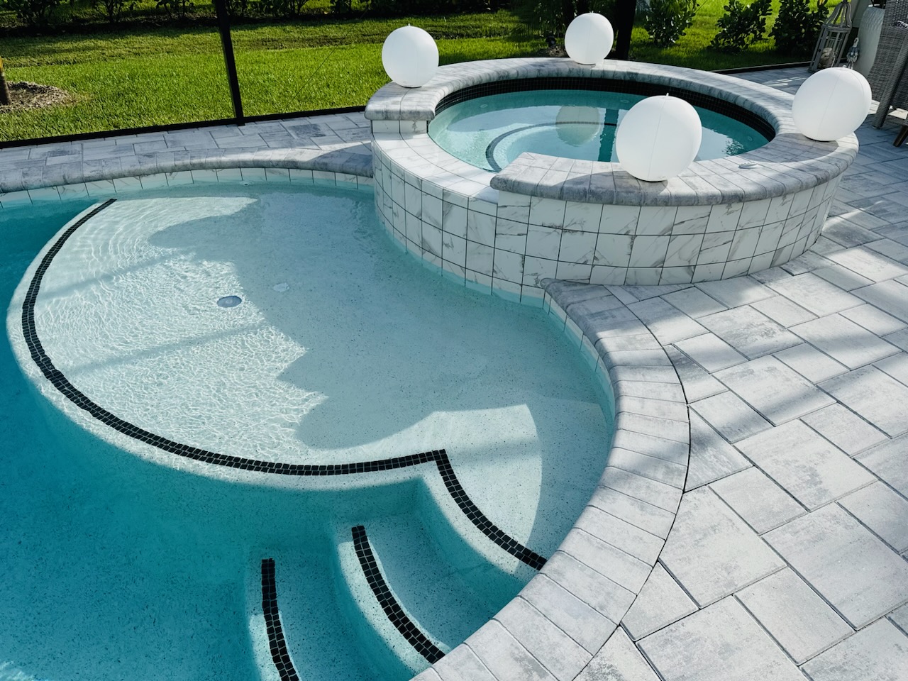 Custom waterfall and faux edge water feature engineered into a concrete pool shell by Design Concepts