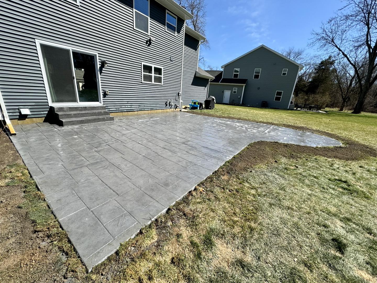 Stamped concrete patio behind a two-story home in Metro Detroit