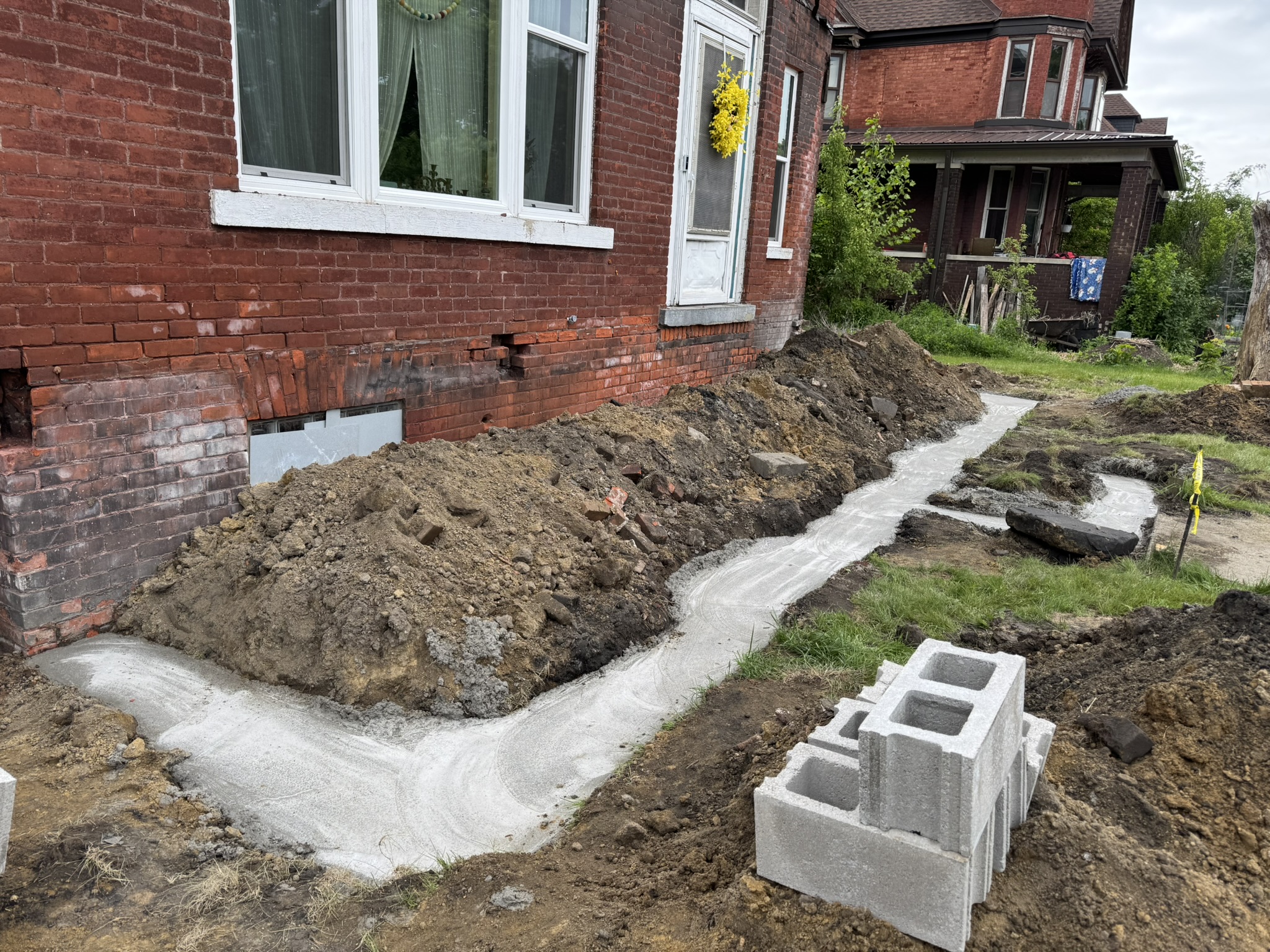 Poured concrete trench footing along a brick home