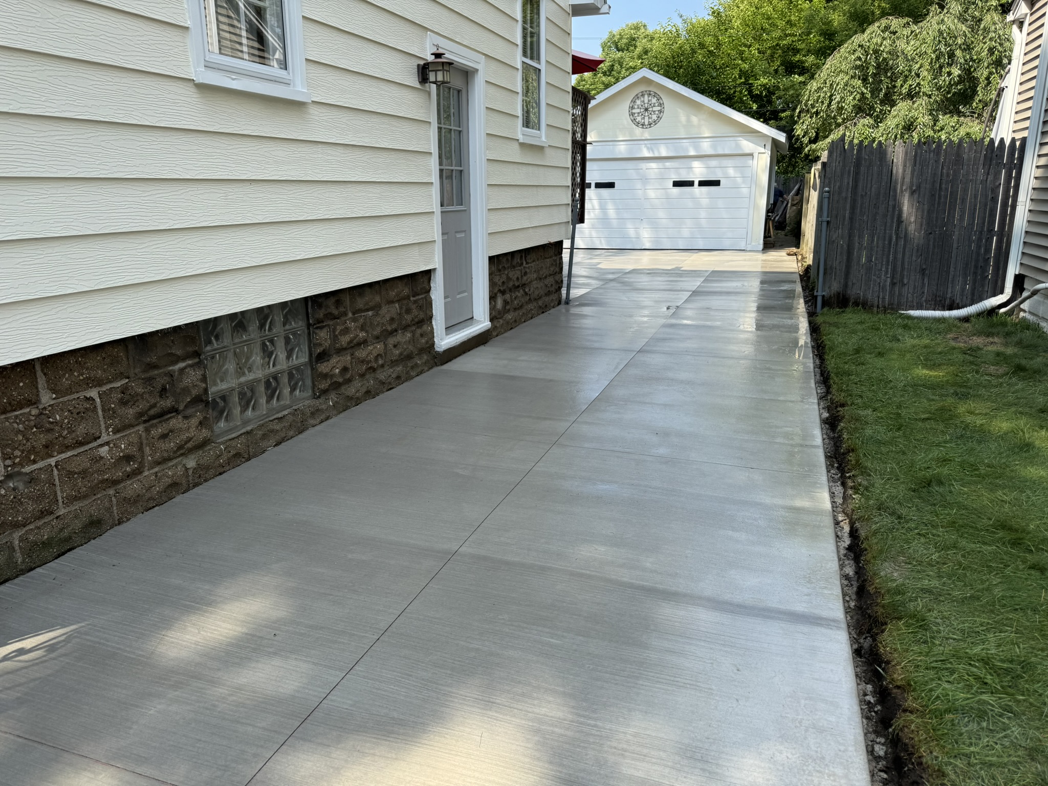 Concrete side walkway leading to a detached garage