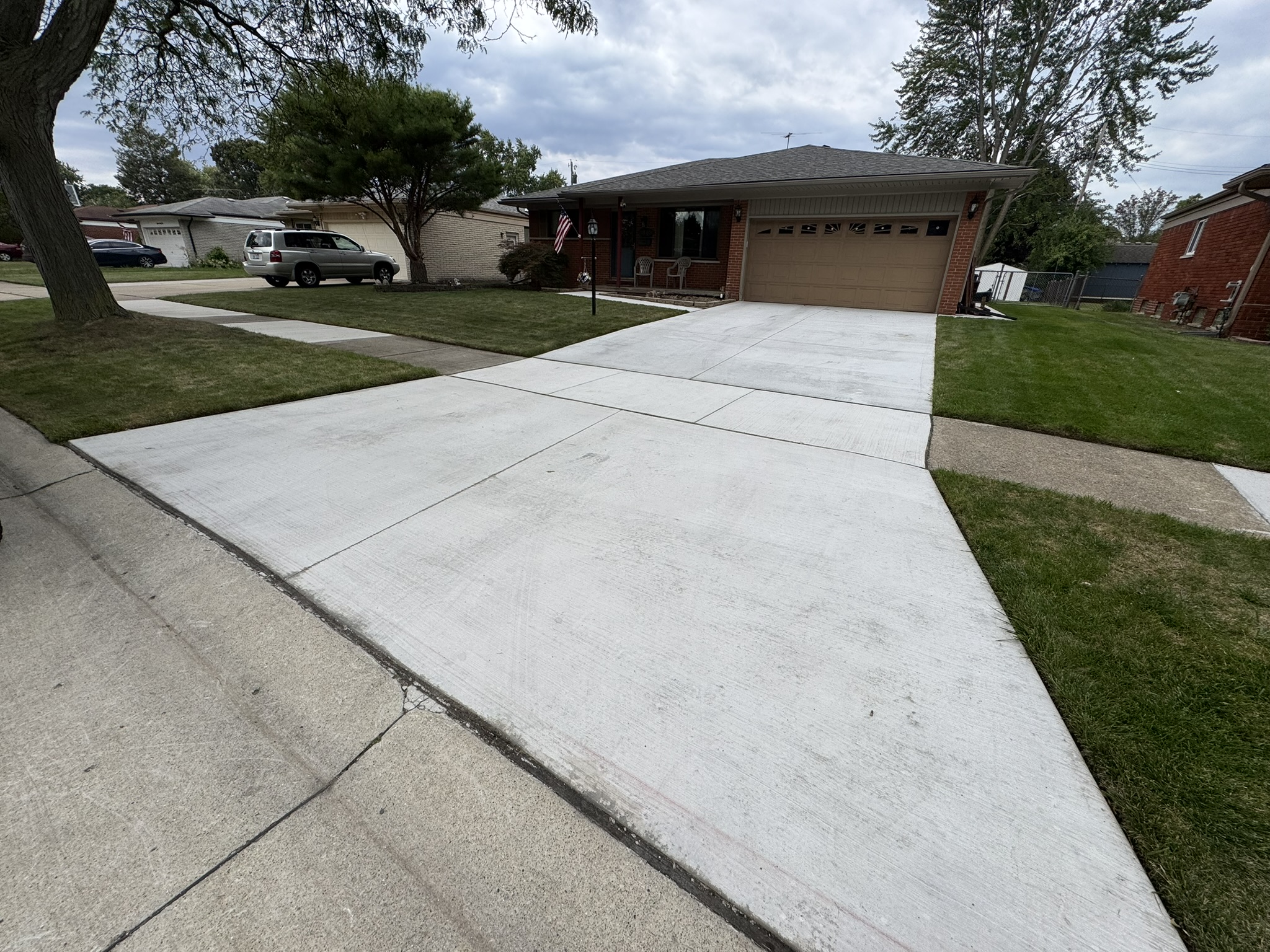 New concrete driveway leading to an attached garage