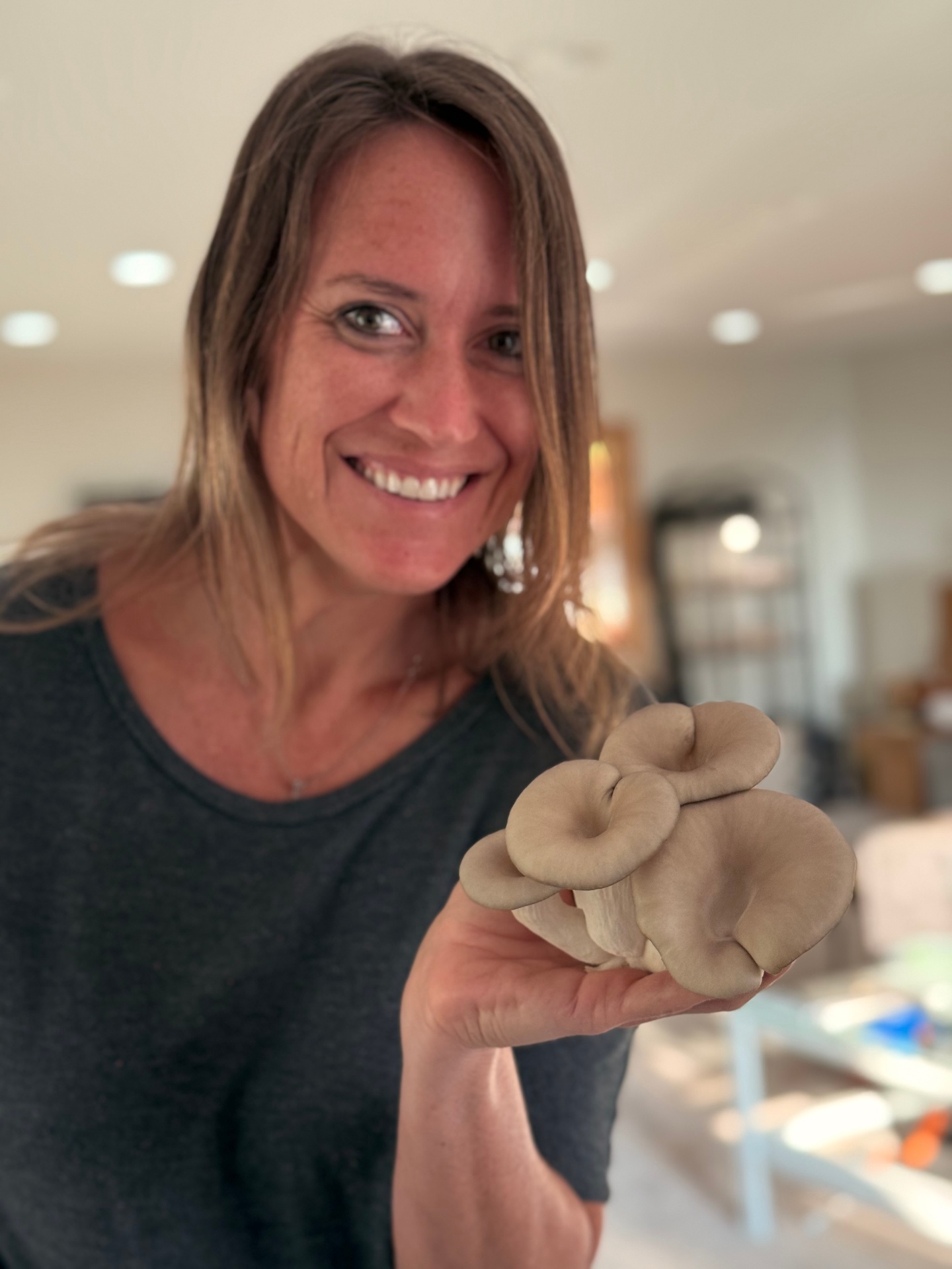 Angela holding fresh mushrooms she grew