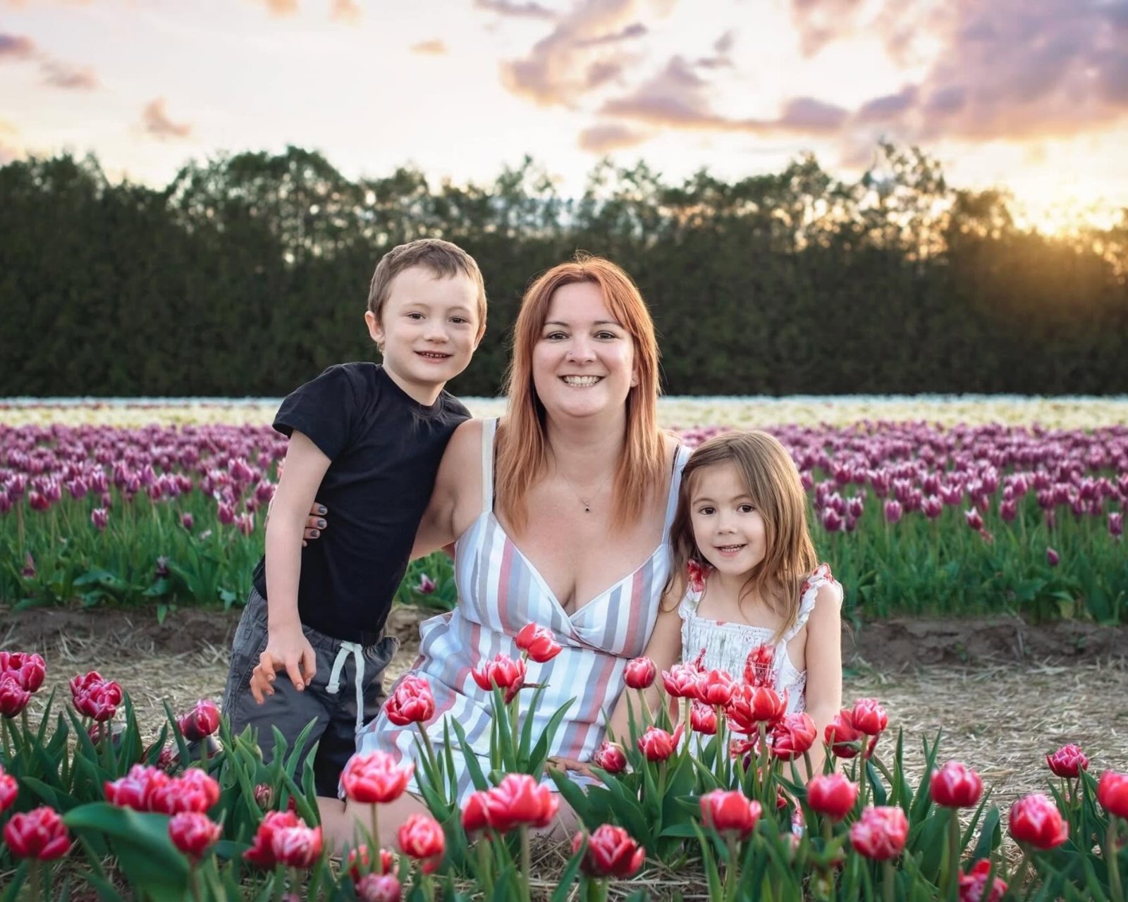 Tori with her two children in a tulip field at sunset