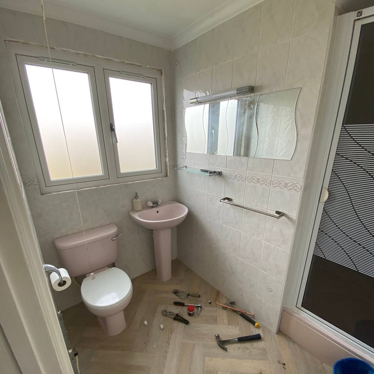 Dated bathroom with pink suite before renovation