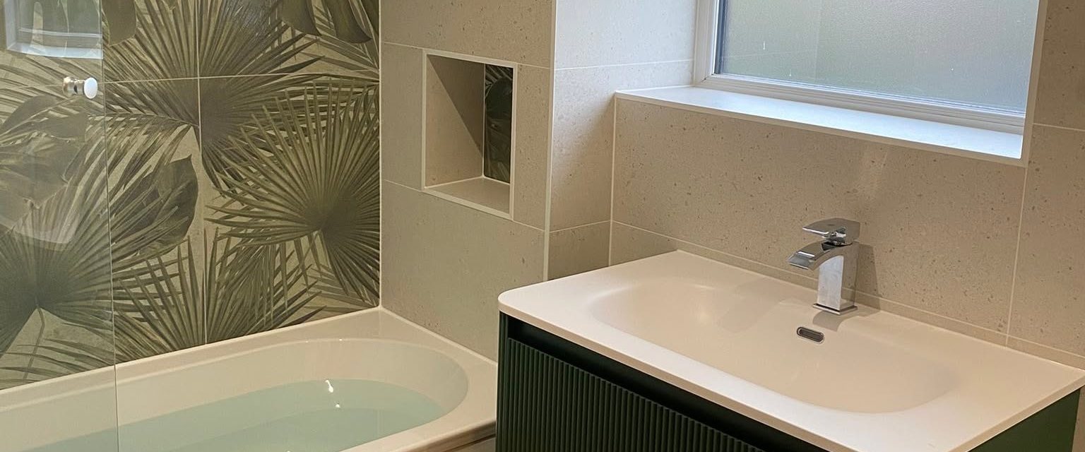 Bathroom with palm leaf feature tiles and green fluted vanity unit