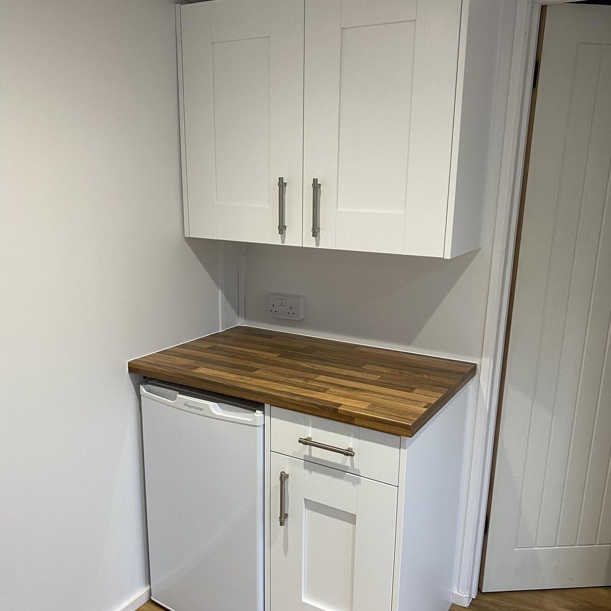 Utility area with white shaker cabinets and oak worktop