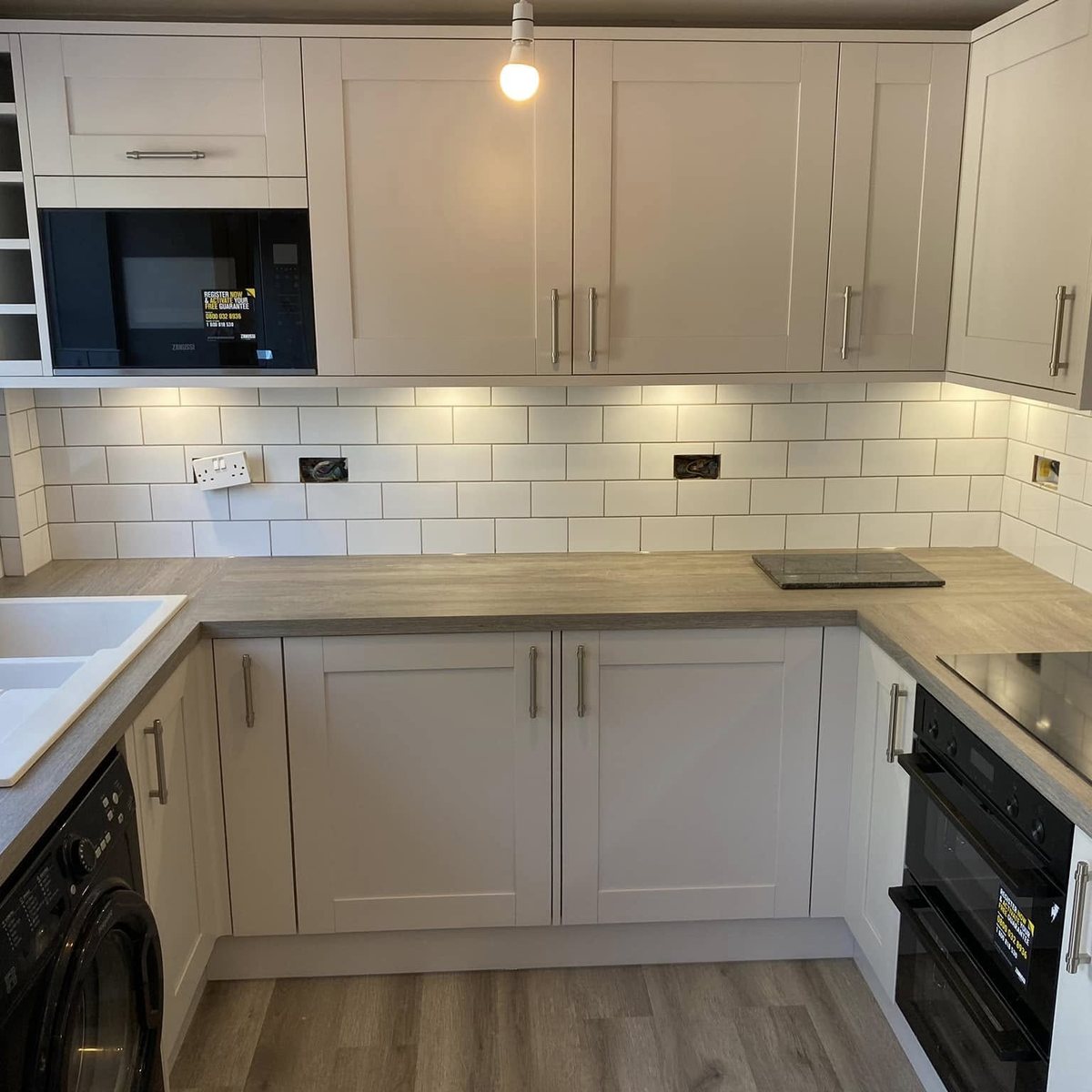 Cream shaker kitchen with white metro tiles, built-in microwave and double oven