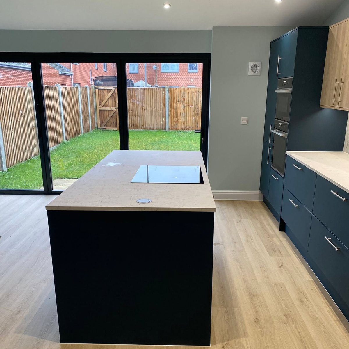 Navy kitchen island in a rear extension with bifold doors