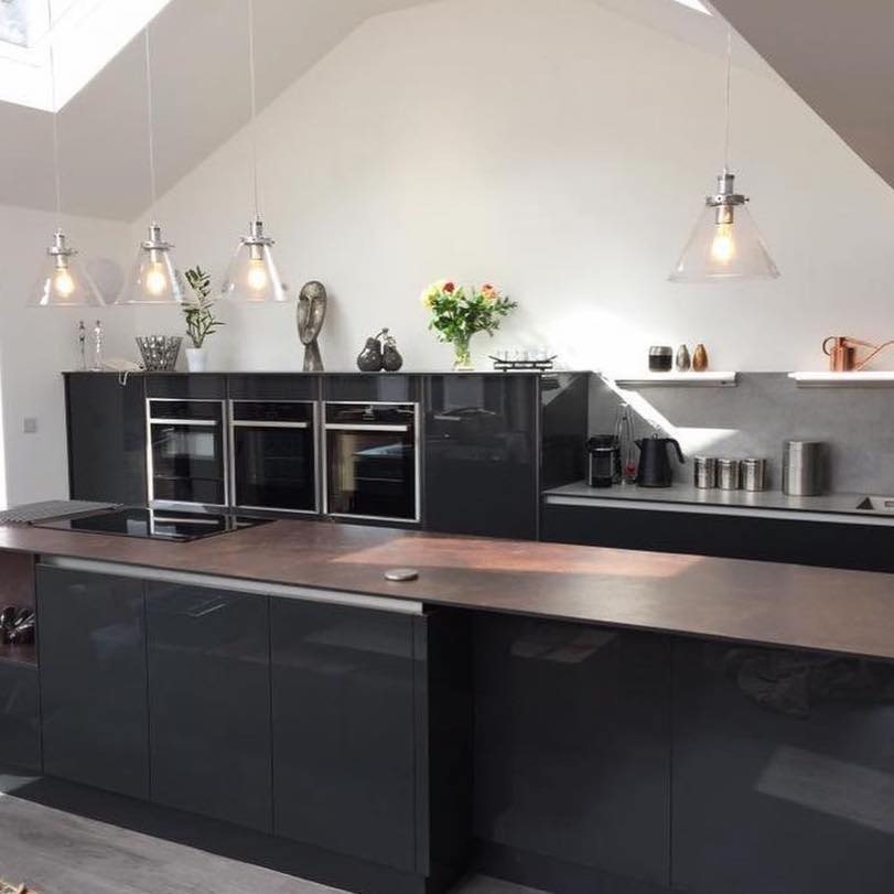 Black gloss handleless kitchen with integrated ovens and breakfast bar