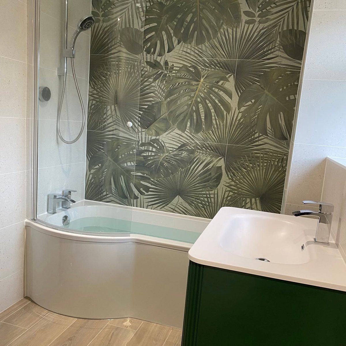 P-shaped shower bath with palm leaf feature wall tiles