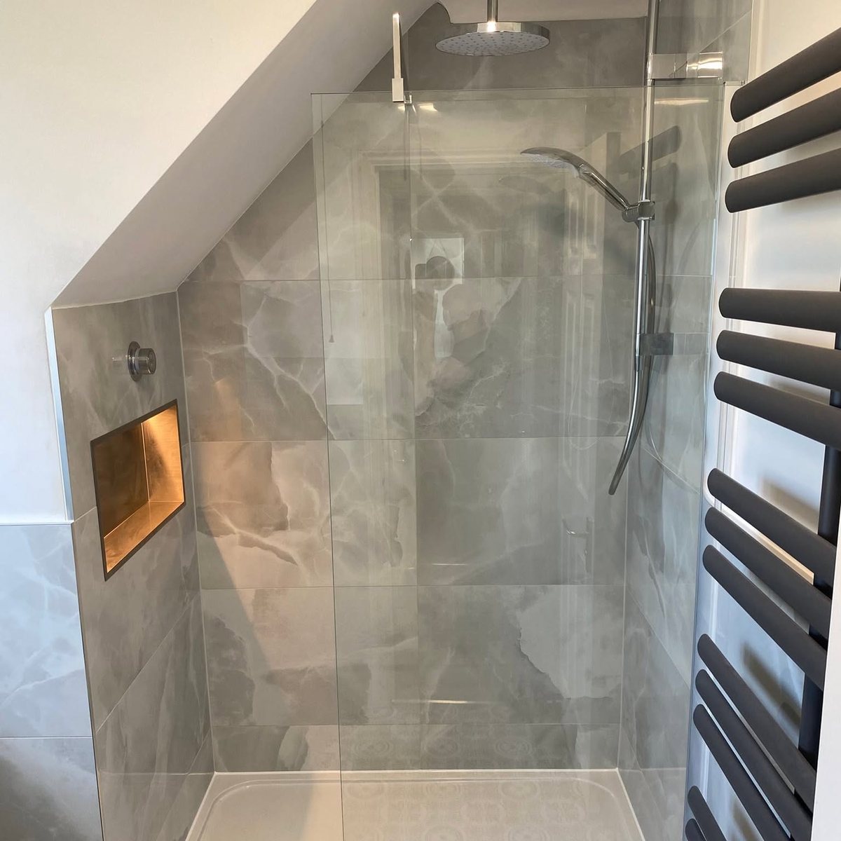 Loft shower room with lit niche under a sloping ceiling