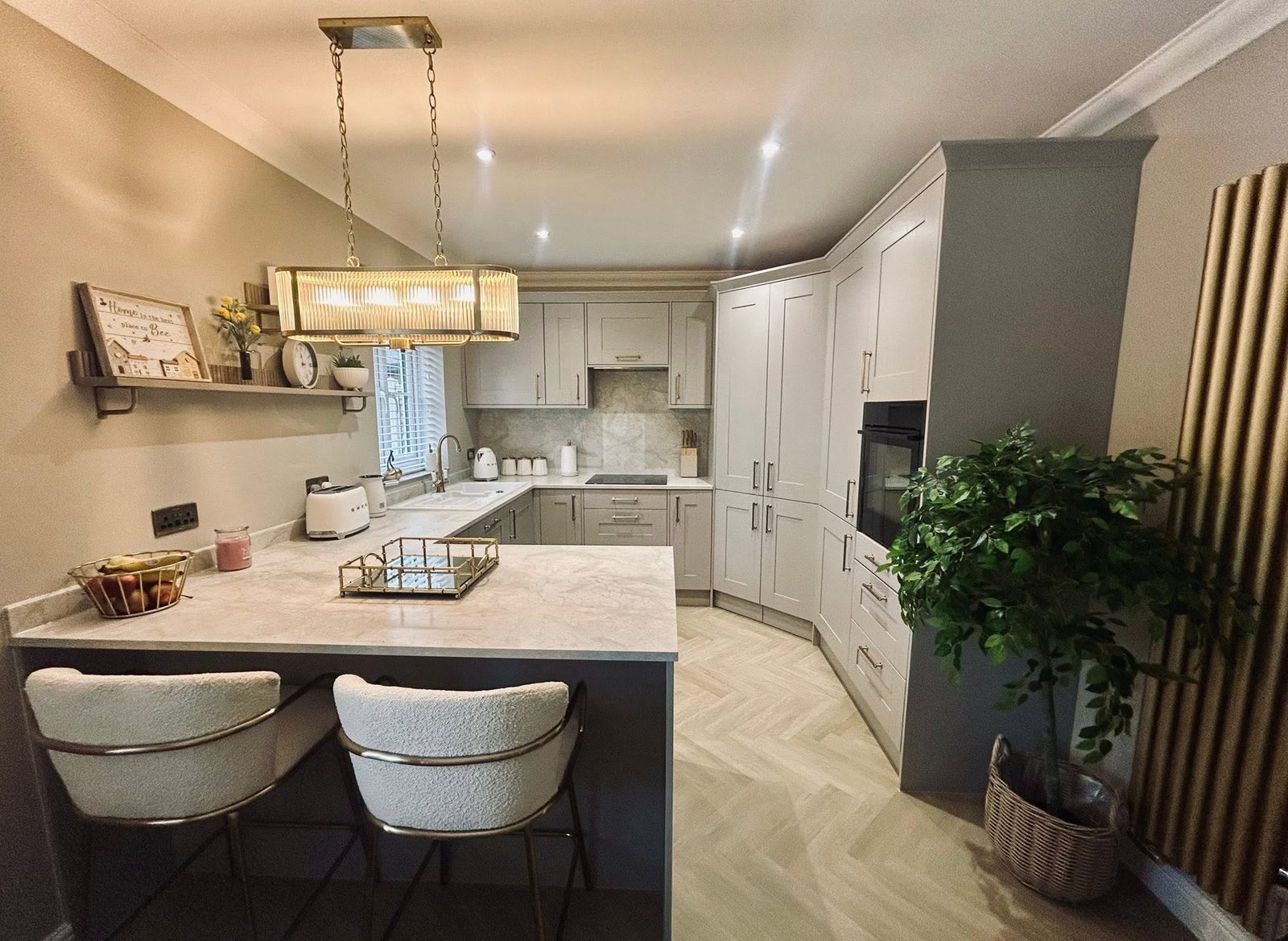 Grey shaker kitchen with marble effect island and statement pendant light, fitted in Suffolk by tradeMark Kitchens