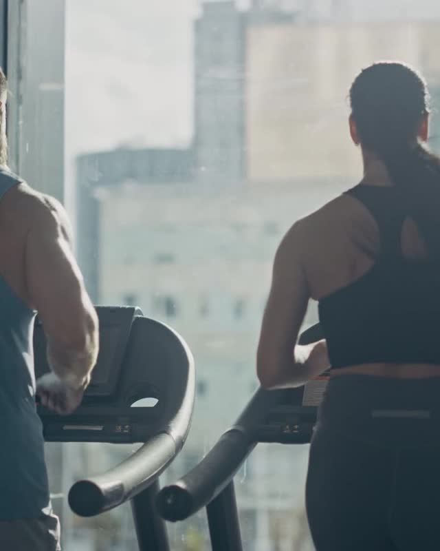 A man and a woman walking on treadmills