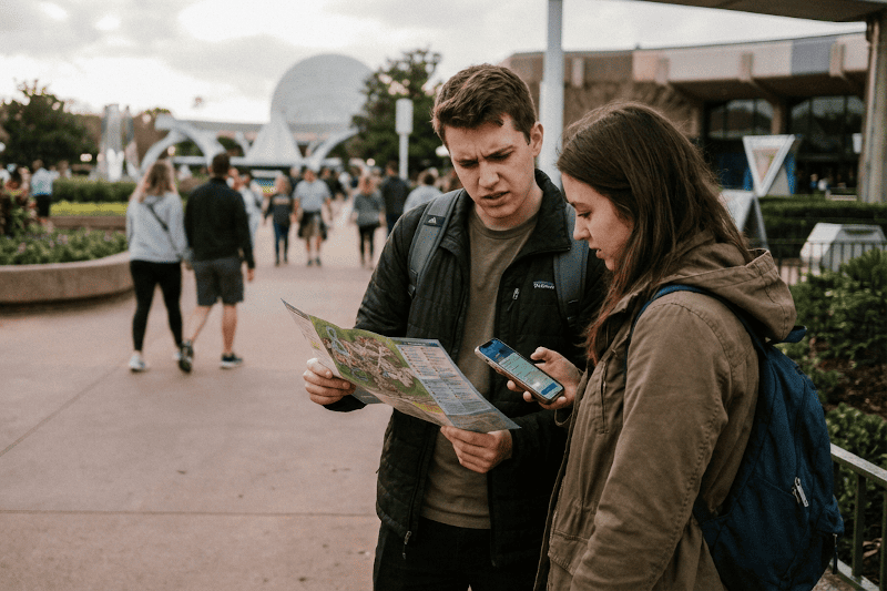 Persona mirando el mapa del parque y el móvil para planificar el día en Disney