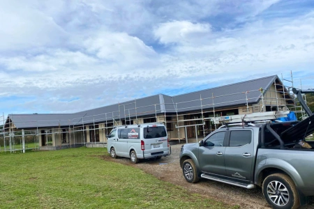 Work vehicles next to recent roofing job