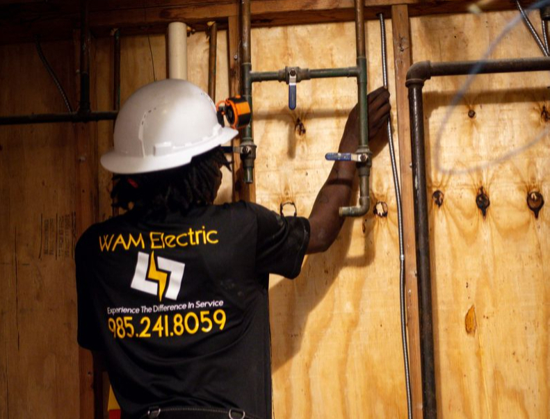 Professional electrician from WAM Electric ensuring electrical code compliance during a home rewire.