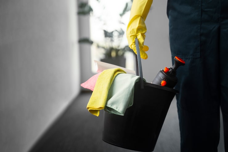 Reinigungskraft reinigt einen modernen, hellen Büroraum