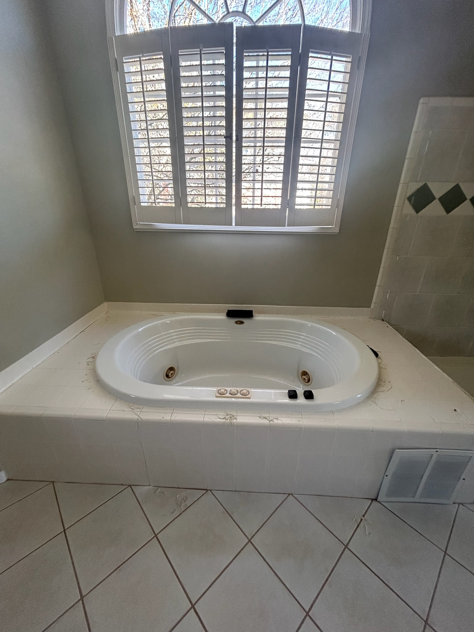 Bathroom floor before grout restoration near jacuzzi tub in Woodstock GA